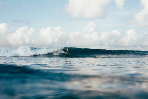 sportswoman in wetsuit having fun while surfing on sunny day