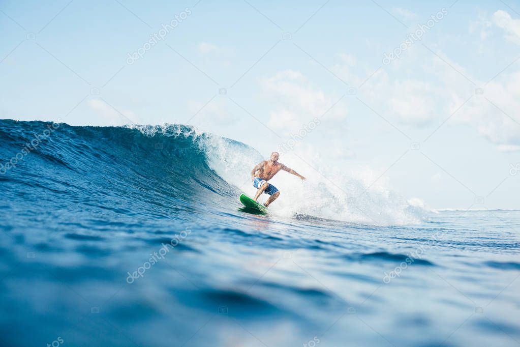 young sportsman having fun on surfboard on sunny day