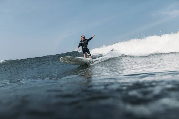 Mann hat Spaß und surft Welle an Bord im Ozean — Stockfoto