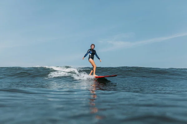 Sportlerin hat Spaß und reitet Welle auf Surfbrett im Meer — Stockfoto