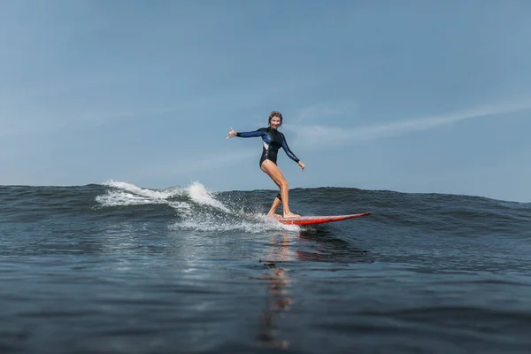 Femme s'amuser et monter vague sur planche de surf dans l'océan — Photo de stock