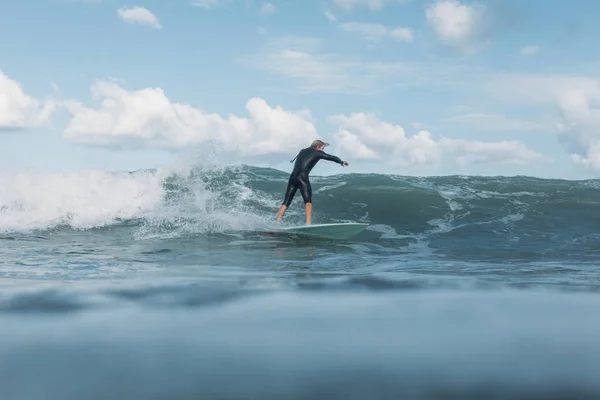 Surfista masculino montando olas en tabla de surf en el océano - foto de stock