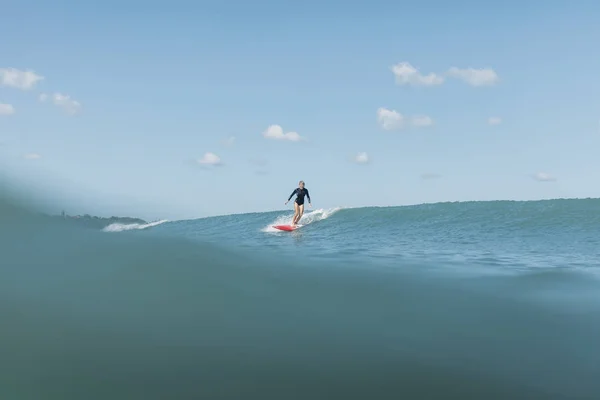 Surfista donna che cavalca onda su tavola da surf in oceano — Foto stock