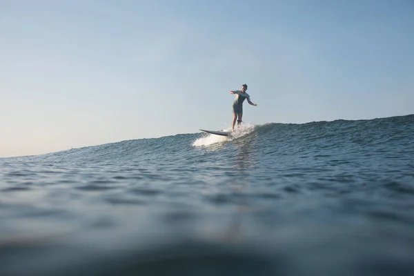 Deportista surfeando la ola en tabla de surf en el océano - foto de stock