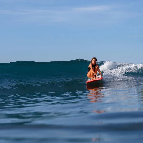 Young slim girl surfing in ocean — Stock Photo