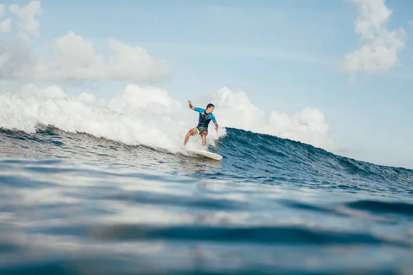 Vista laterale del giovane sportivo in muta che si diverte sulla tavola da surf nella giornata di sole — Foto stock