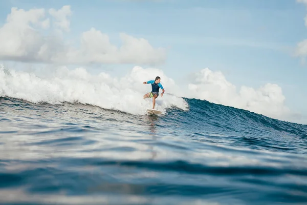 Schöner junger Mann im Neoprenanzug, der an sonnigen Tagen Spaß auf dem Surfbrett hat — Stockfoto