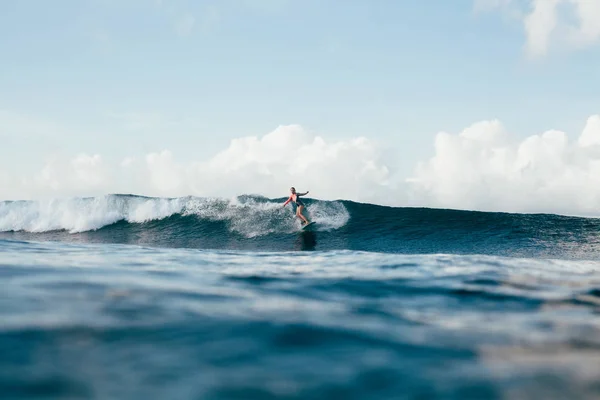 Jovem desportista em wetsuit surf no dia ensolarado — Fotografia de Stock