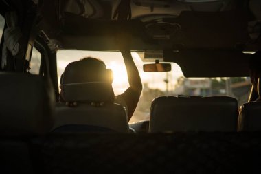 bir araba, Altın ışık ile seyahat Vietnames otobüs içinden güzel günbatımı atış güneş kalkanı çevirmek için elini sürücü yükseltme