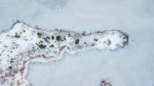 frozen island shot with a drone from above, water paradise, frozen winter wonderland, lake