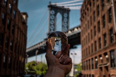  Manhattan Köprüsü 'nün kulelerinden birinin mercektopu manzarası Dumbo bölgesinin sokaklarından, Brooklyn, Nyc, kristal küre görüntüsü.