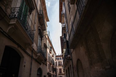 Palma de Mallorca 'nın sokaklarında, arka planda büyük gökyüzü, büyük şehir fotoğrafçılığı tipik renklerde küçük bir sokak