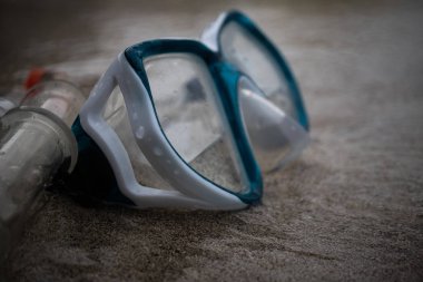 Kumsalda sörf yaparken maske ve şnorkel; kumun üzerinde seçici odaklanma, maske ve şnorkel tüpü