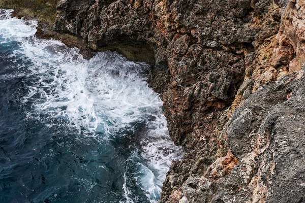 海の波と幻想的なロッキー海岸の空中ビュー、嵐の前にスプレーと泡で岩の海岸に墜落する危険海の波 — ストック写真