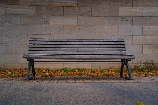 柏林市中心的旧木制长椅，隔离在石墙前的长椅上 — 图库照片