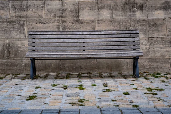 Vecchia panca in legno nel cuore della città di Berlino Germania, panchina isolata di fronte a un muro di pietra — Foto Stock