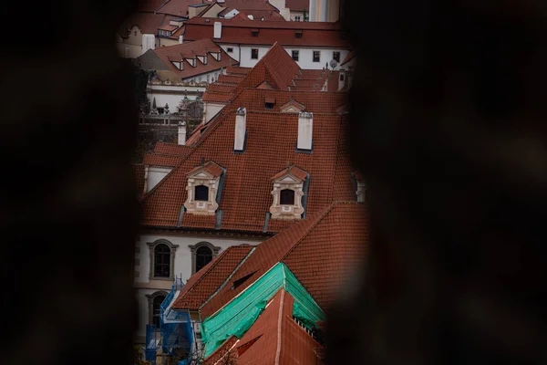 Daken door een spleet in een muur, over de top van Praag in Tsjechië — Stockfoto