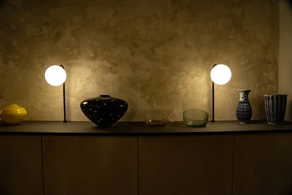 Desk with a great light and a vase on it, vase on a desk, great texture on a wall with a desk in the foreground — 图库照片