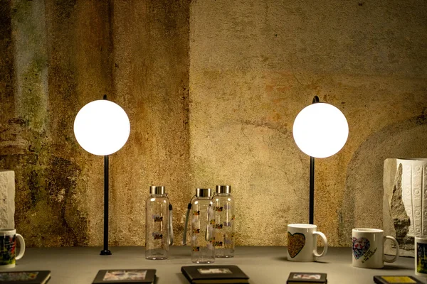 Desk with lights and books on it, great texture wall with a desk in the foreground, amazing lights on a desk full of glasses and books — 图库照片