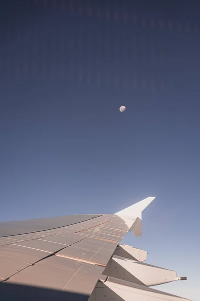 Airplane wing through the airplane window with the moon in the background — 스톡 사진