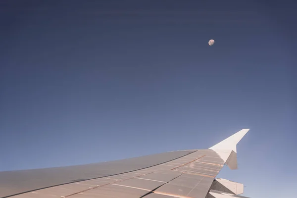 Arka planda ay varken uçak kanadı uçağın penceresinden geçer. — Stok fotoğraf
