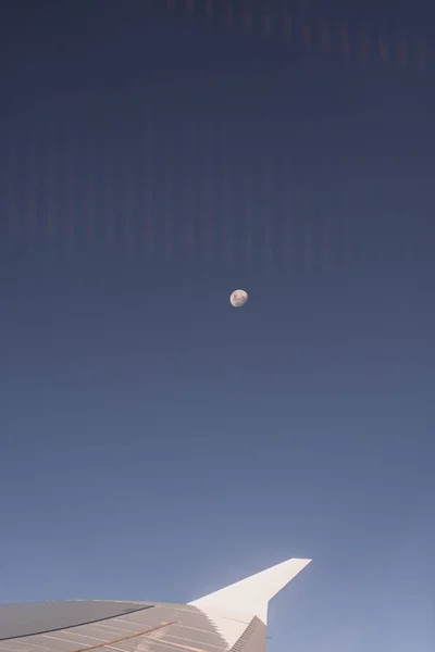 Airplane wing through the airplane window with the moon in the background — 스톡 사진