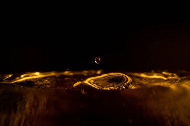 Su sıçraması, altın su sıçraması, siyah arka planda izole edilmiş su, su