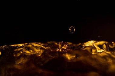 Su sıçraması, altın su sıçraması, siyah arka planda izole edilmiş su, su