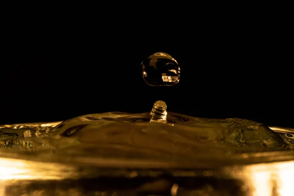 Su sıçraması, altın su sıçraması, siyah arka planda izole edilmiş su, su