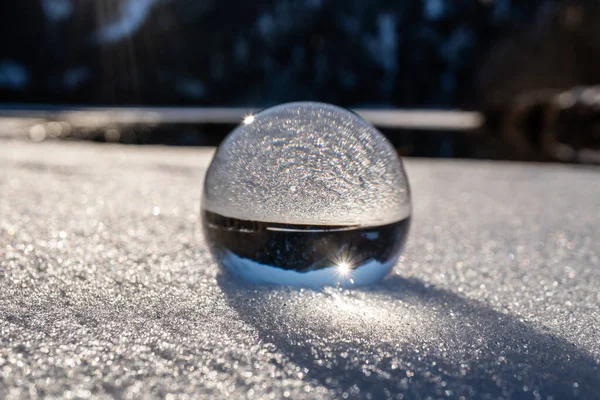 Karda kristal küre. Ön planda mercek topu olan güzel Avusturya Alpleri.