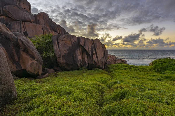 Red granite rocks in the sunrise on la digue on the seychelles 1 — Stock Photo, Image