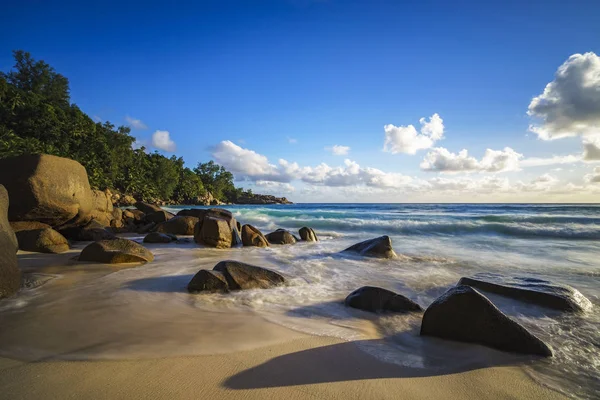 Puesta de sol en paradise.shadows de rocas, playa tropical, anse intendance —  Fotos de Stock