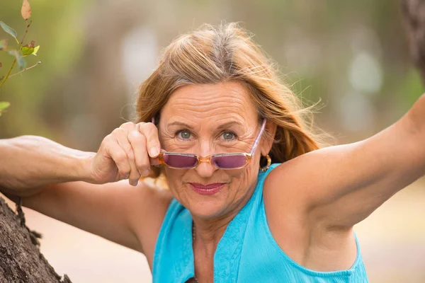 Ontspannen zeker volwassen vrouw zonnebril buiten — Stockfoto