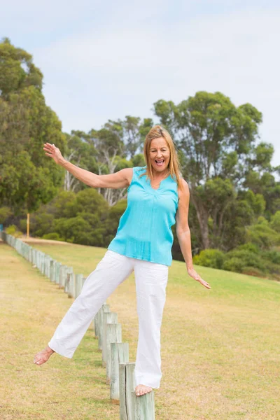 Happy Mature woman balancing outdoor — Stock Photo, Image