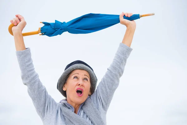 Glücklich reife Frau mit Regenschirm Arme nach oben lizenzfreie Stockfotos