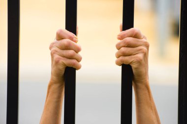 Hapiste parmaklıklar arkasında eller