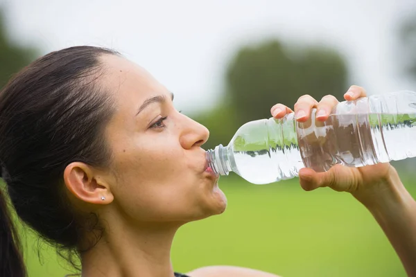 Young exercising woman drinking water — Stock Photo, Image