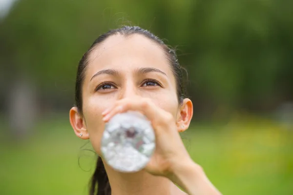 Giovane donna attiva acqua potabile all'aperto — Foto Stock