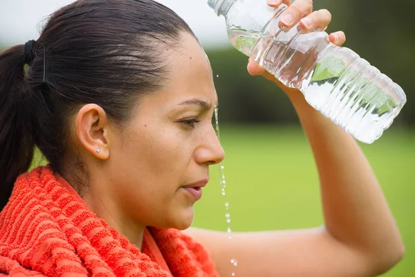 Young active woman spraying water in face — Stock Photo, Image