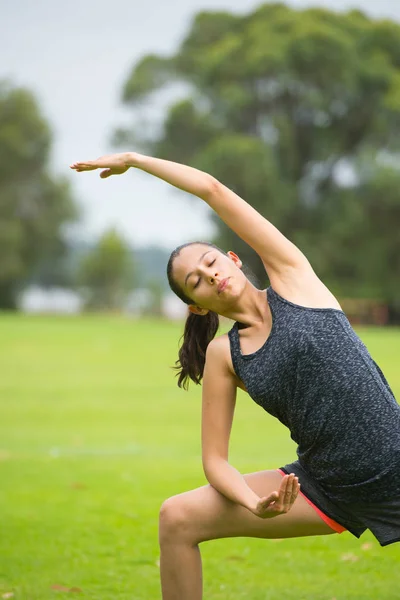 Jonge vrouw uitoefening van yoga in park — Stockfoto