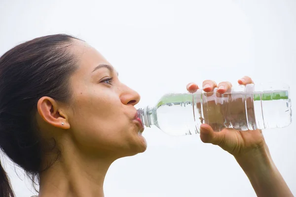 Junge trainierende Frau trinkt Wasser Stockbild