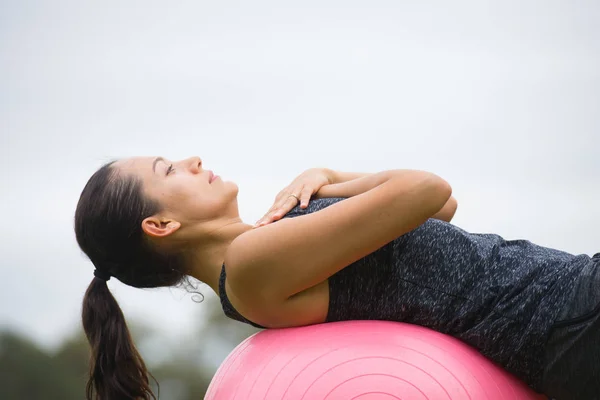 Fit Young woman yoga exercise on fit ball outdoor Stock Photo