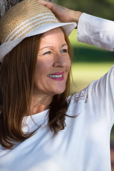 Gelukkig ontspannen vrouw met hoed in park buiten — Stockfoto