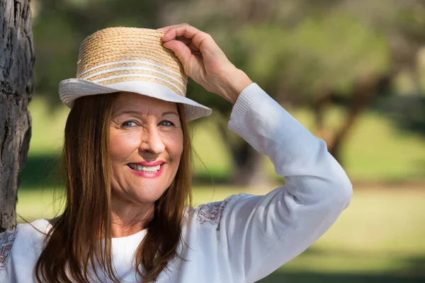 Lycklig avslappnad kvinna med hatt i parken utanför — Stockfoto