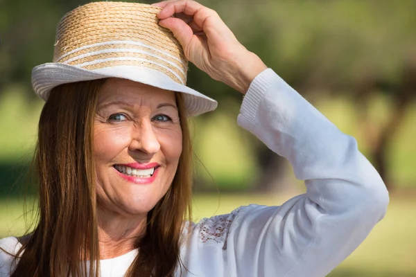 Счастливая расслабленная женщина в шляпе в парке на улице — стоковое фото