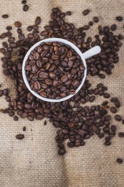 Kahve arka plan üzerinde beyaz bir fincan kahve