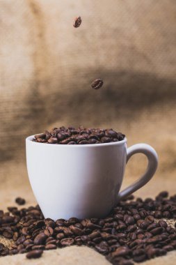 Kahve arka plan üzerinde beyaz bir fincan kahve