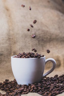 Kahve arka plan üzerinde beyaz bir fincan kahve