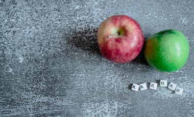 Gri arkaplan, üstten kırmızı ve yeşil elma manzaralı. Rusça yazılmış elmalar..