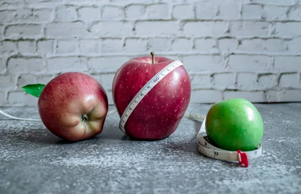 red and green apple for weight loss while dieting, centimeter measuring tape